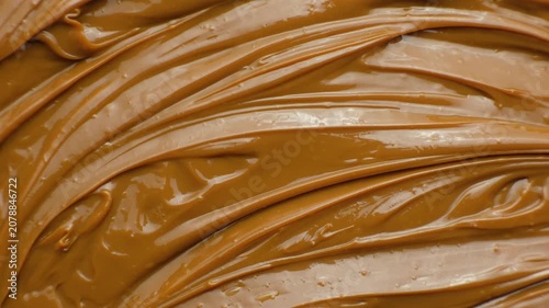 Boiled condensed milk texture or dulce de leche background top view