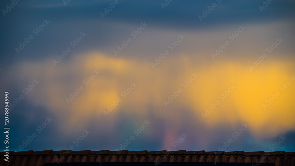 Naklejka premium Bizarre colorful sky sight over rooftop