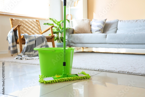 Mop with bucket on floor in...