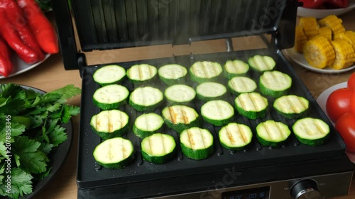 Organic Zucchini Rounds Grilling with Visible Steam and Grill Marks