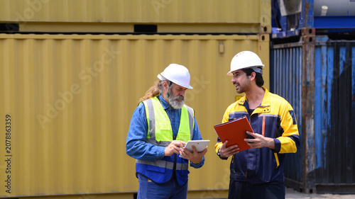 Shipping supervisors discussing freight container management at commercial logistics terminal.