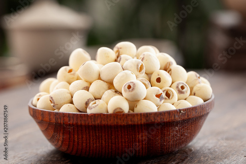 Foto Dried White Lotus Seeds in Wooden Bowl - Traditional Asian Cooking Ingredient