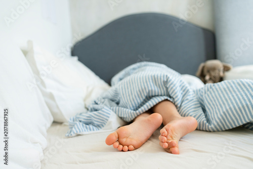 Legs of girl lying on bed at home