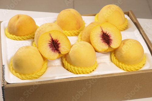 Fresh Yellow Peaches in Gift Box with Protective Mesh Packaging Indoor Studio Shot