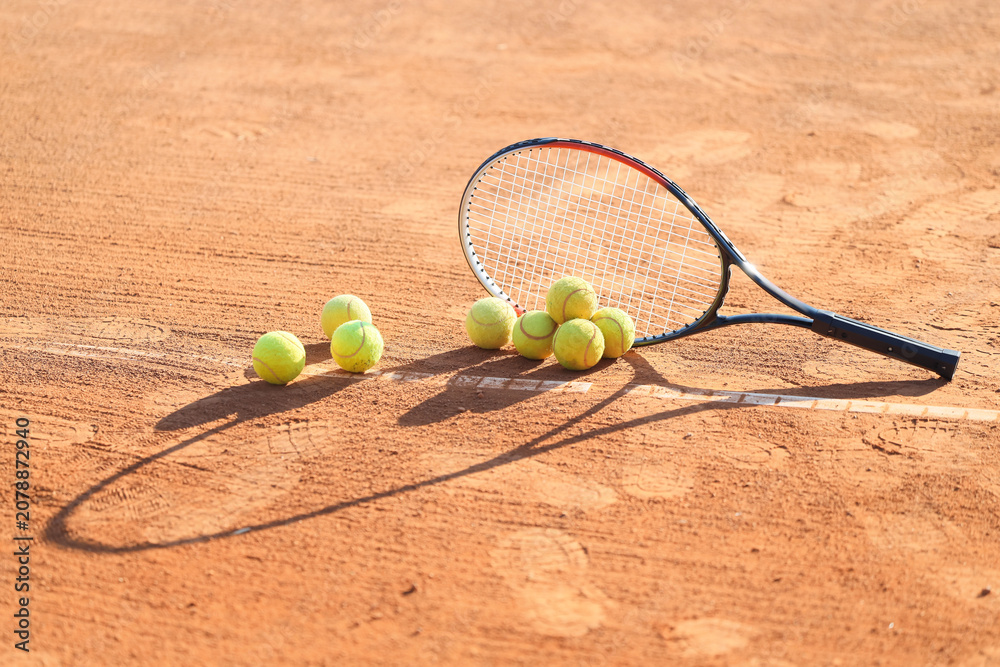 Obraz premium Racket with tennis balls on court