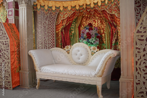 Foto Traditional Minangkabau wedding dais with elaborate wooden carvings, decorative