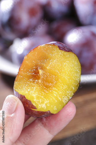 Bilde på lerret Fresh Cut Xinjiang Prune Showing Golden Sweet Flesh in Hand - Studio Food Photog