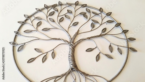 Metallic wire arranged in an intricate tree formation with delicately shaped leaves displayed in a flat lay setting