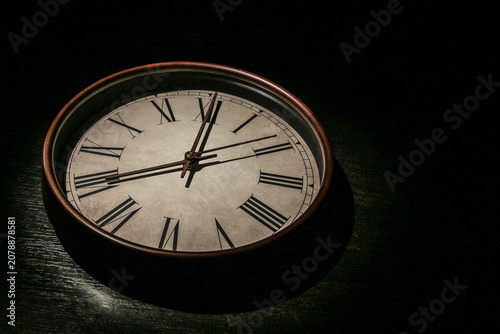 Photography Vintage Wall Clock with Roman Numerals in Dramatic Light
