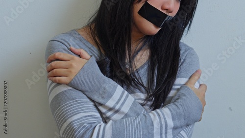 Fotografie Terrified Young Woman With Tape Over Her Mouth Crosses Her Arms In Fear