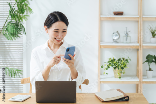 Fotografie 笑顔でスマホを見るミドル女性。アプリ、SNS、動画、お得、クーポン、ポイント、ポイ活、ネット通販