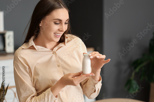 Young woman with bottle of ...