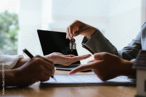 Fotografía Real estate agent handing over house keys after signing a property agreement, symbolizing home ownership, closing deals, and successful transactions