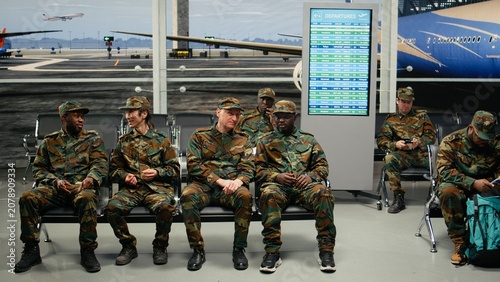 Tableau sur toile Chatting, plane arrival and smiling military squad waiting in airport lounge, Talking, long flight layover with man and team with happy and busy