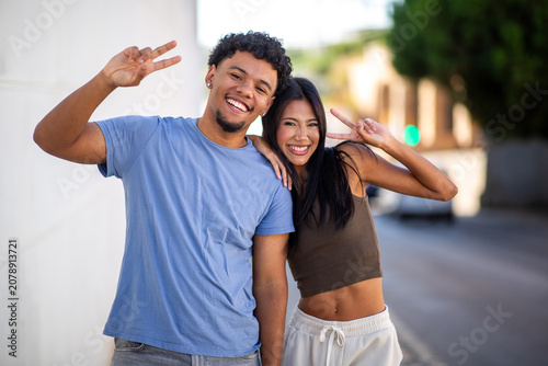 Happy couple making peace signs outdoors