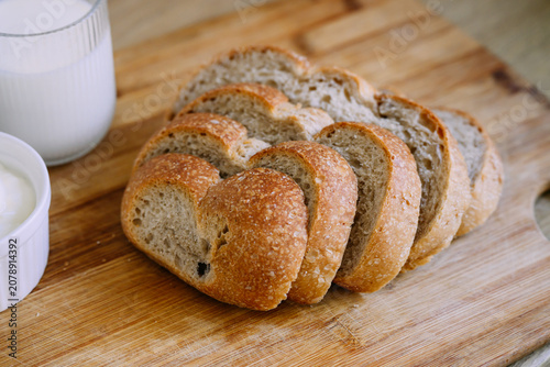 Freshly baked sourdough bread loaf with a crispy crust, partially sliced for eating