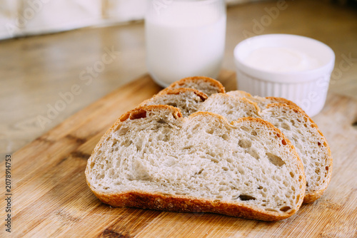 Freshly baked sourdough bread loaf with a crispy crust, partially sliced for eating