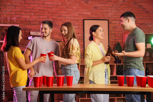 Group of young friends drinking beer at party
