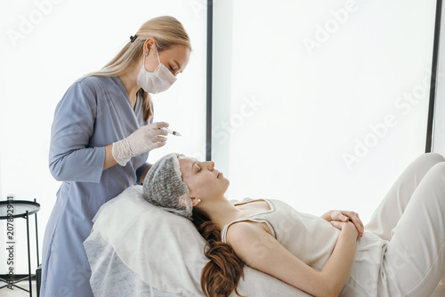 A young woman at a cosmetologist's appointment, improving her skin with a dermatologist, self-care, beauty injections, fillers