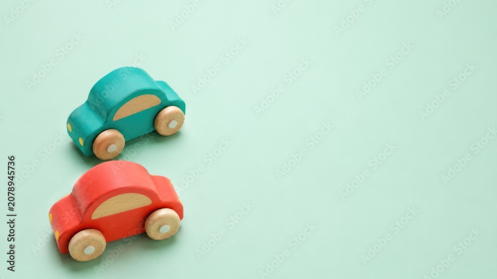 Fototapeta premium Colorful Wooden Toy Cars on Soft Pastel Background with Copy Space