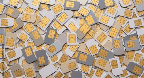 Scattered collection of various SIM cards with gold contacts, viewed from directly above mobile phone