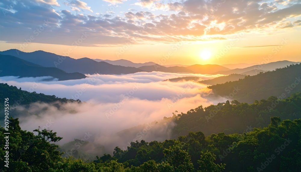 Naklejka premium Breathtaking sunrise over misty mountains and lush green valley.
