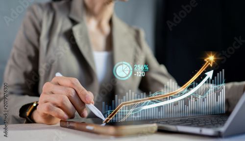 Foto Businesswoman using tablet and stylus to analyze growing financial stock chart,