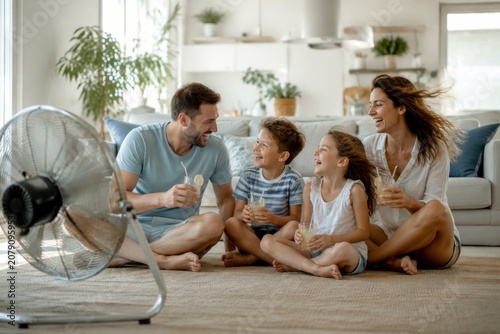 Family enjoying summer fun together, laughter and ice cream in a cozy living room.