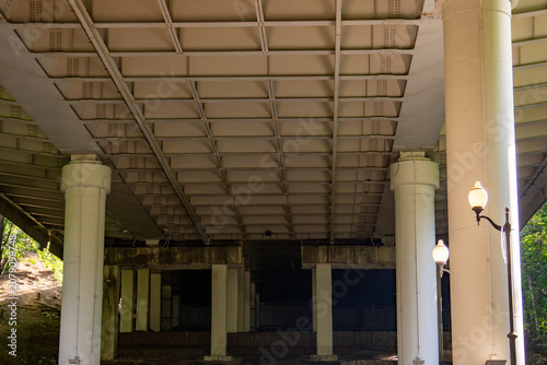 Epic steel beams under bridge overpass architecture texture background. 
Cinematic horizontal pattern of heavy industrial concrete pillar support, 
highway flyover metal construction and hard shadow c
