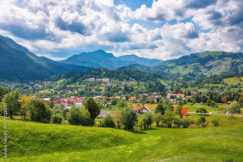 Obraz premium Amazing alpine landscape with green fields and Piatra Craiului mountains in Dambovicioara Commune.
