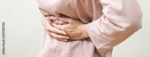 Φωτογραφία Flatulence asian young woman intolerance hand in stomach ache, suffer from food poisoning, abdominal pain and colon problem, gastritis or diarrhoea when at home
