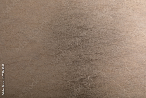 Detailed view of a textured metallic surface showing fine scratches and subtle light reflections.