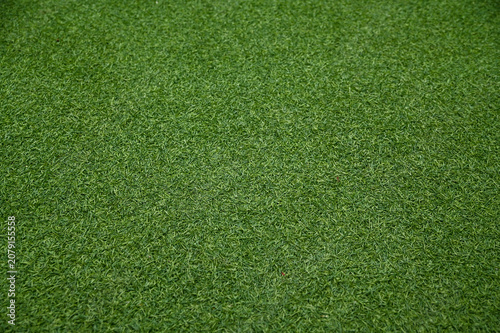 A top-down full frame view of uniform vibrant green artificial grass turf texture.