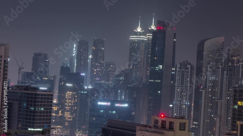 Foggy night skyline elevated timelapse documenting the local layout in Business Bay. The incredible weather phenomenon completely transforms the local urban scenery. Modern styles.