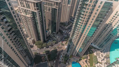 Curved road infrastructure overhead timelapse sequence captured clearly above Downtown Dubai. The complex curved road networks weave seamlessly between the immense tower bases.