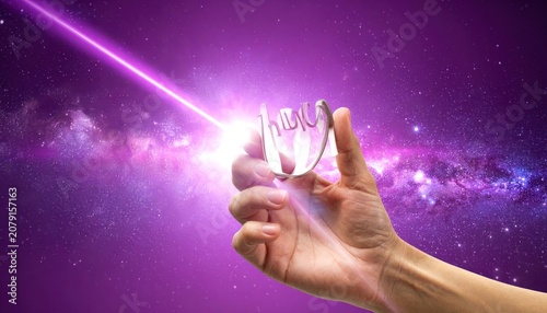 A hand holds a shiny metallic object with the word 