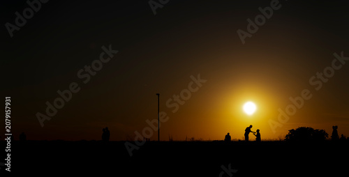 Panoramic view of people relaxing and talking during golden hour at dusk