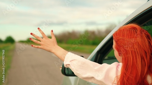 Fotografie Female student drives car towards wind and adventure