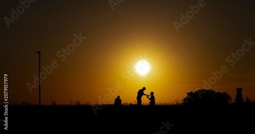 Panoramic view of people relaxing and talking during golden hour at dusk