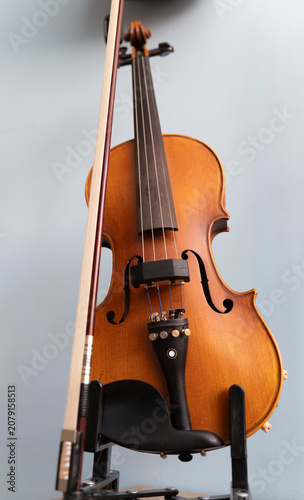 Vertical low angle shot of a classic wooden violin with its bow