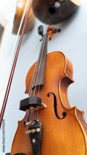 Vertical low angle shot of a classic wooden violin with its bow