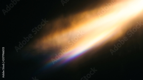 Abstract golden light beam with rainbow spectrum on dark background for creative design
