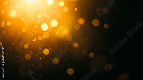 Golden bokeh light abstract background with glowing particles for festive and celebratory designs