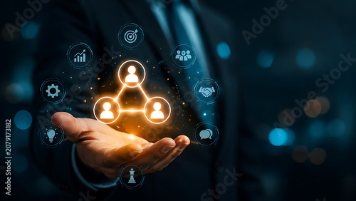 Business leader presenting glowing team network interface with collaboration handshake strategy analytics innovation and communication icons in futuristic workplace for management success concept
