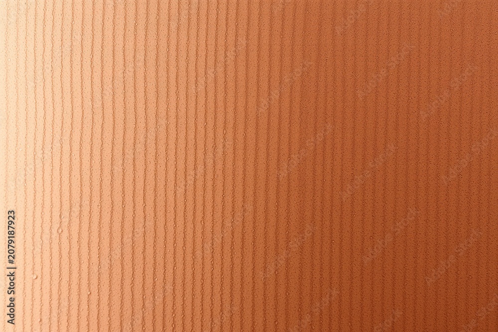 Fototapeta premium Vertical lines create textured orange surface. Gradient effect present, lighter top to darker bottom. Simple, uniform pattern dominates image.
