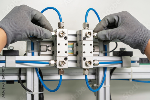 Photos Hands in gloves adjusting pneumatic valves on industrial machinery
