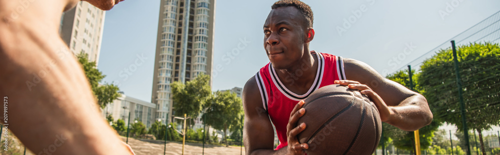 Obraz premium Young men enjoy summer street basketball on a vibrant outdoor court together