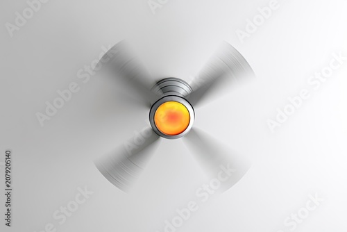Close-up overhead view of a spinning ceiling fan with bright illuminated center