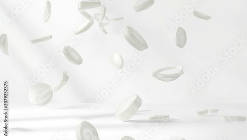 Slices of white onion flying in midair on white backdrop