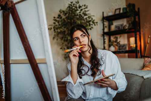 Artist creating painting, thoughtfully composing new ideas for canvas